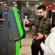 couple using atm machine at retail mall
