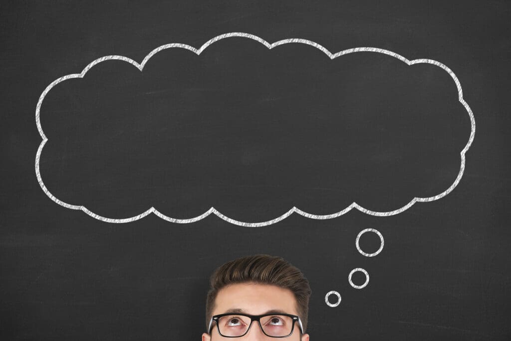 A person with glasses looks up at a large empty thought bubble drawn in white chalk on a blackboard background, perhaps pondering the concept of reverse ATMs. Only the top part of the person's face and head are visible.